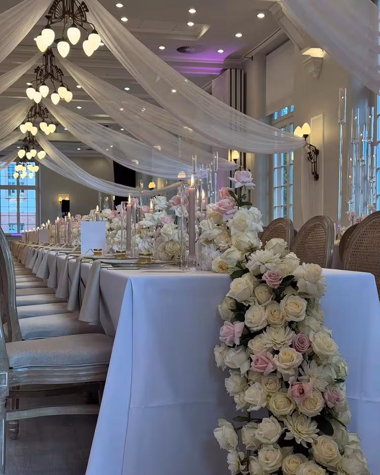 Aura Location mit gedeckter Hochzeitstafel, Drapierung und Kronleuchtern